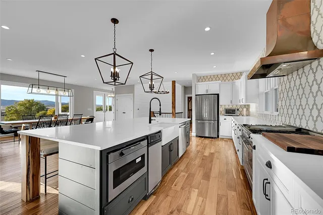 a kitchen with white cabinets appliances and center island