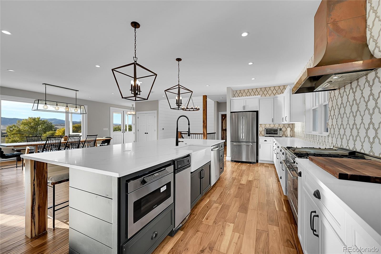 810 North Perry Park Road Sedalia, CO 80135 - Photo 12 of 46 a kitchen with white cabinets appliances and center island