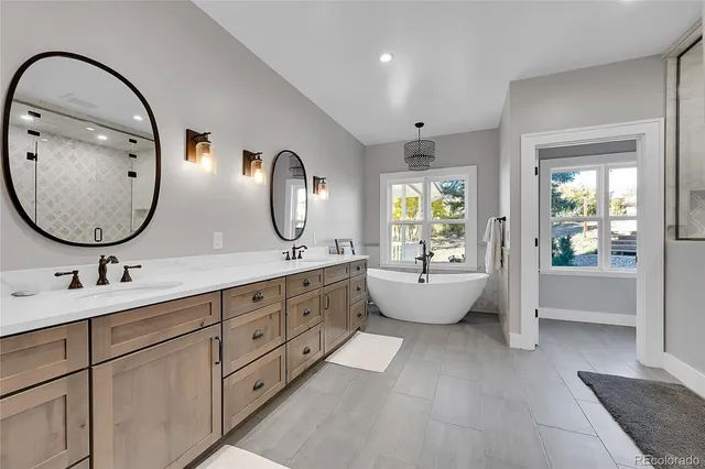 a spacious bathroom with a double vanity sink mirror and bathtub