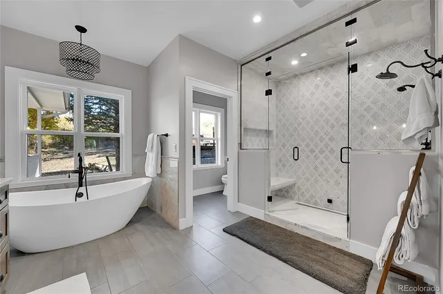 a large spacious bathroom with a tub shower and mirror