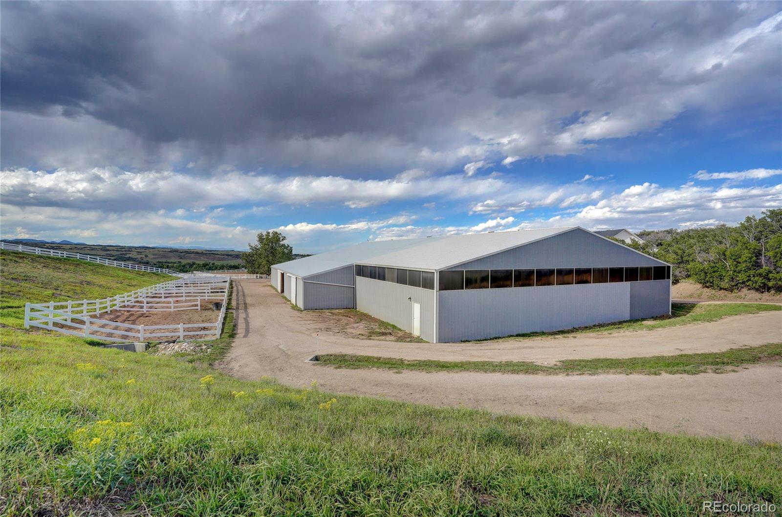 810 North Perry Park Road Sedalia, CO 80135 - Photo 35 of 46 a view of a big house with a big yard and a large tree