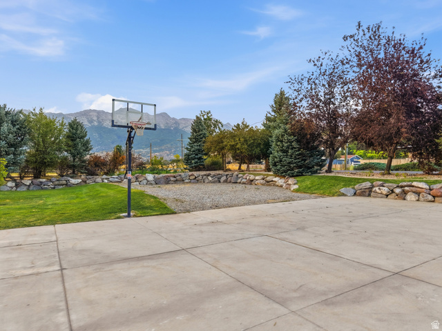 702 Alpine Highway Alpine, UT 84004 - Photo 78 of 83 Expansive concrete paved area with a basketball hoop, surrounded by manicured lawns and mature trees