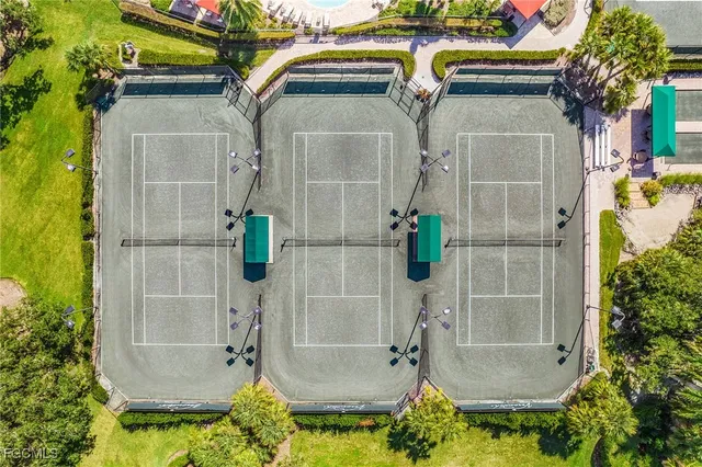 a view of a brick house with plants and large trees