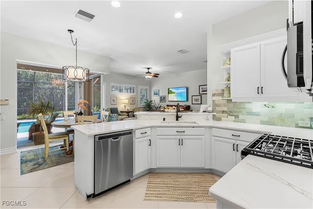 a kitchen with kitchen island a sink stainless steel appliances and white cabinets