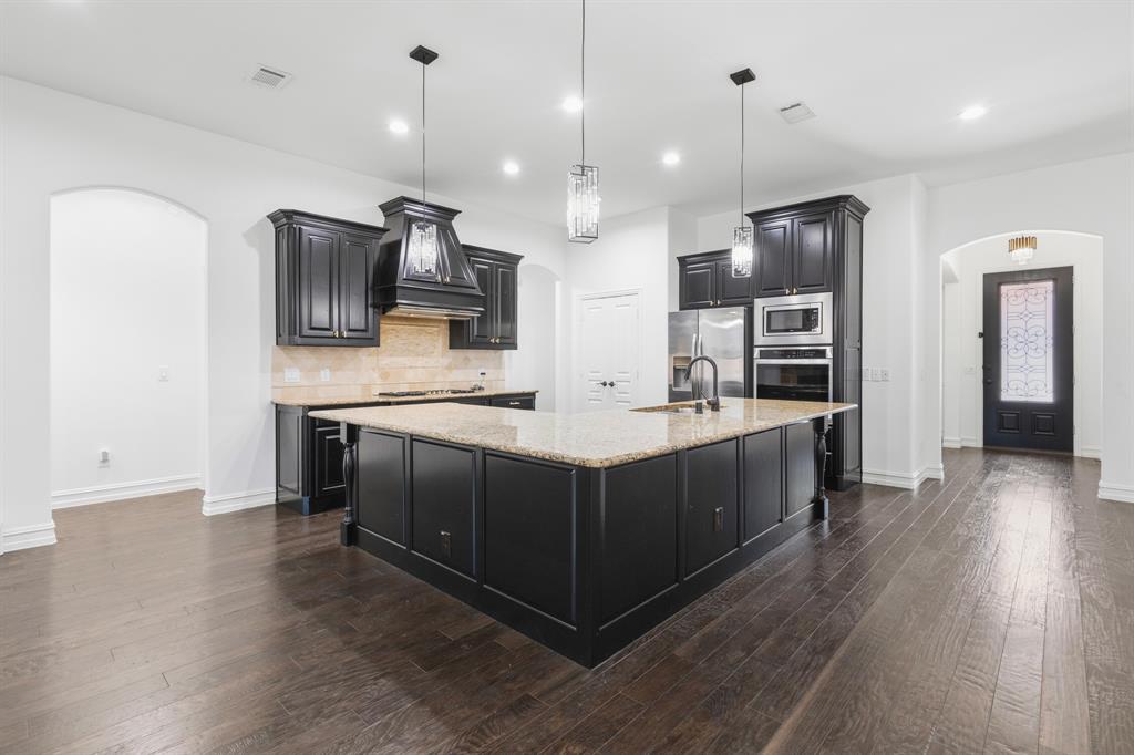 1995 Verde Court Allen, TX 75013 - Photo 20 of 30 Open-concept kitchen featuring dark wood cabinetry, granite countertops, an undermount sink, and recessed lighting