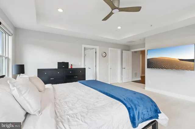 a large bedroom with a bed and a flat screen tv