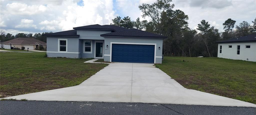 2673 Southwest 156th Place Ocala, FL 34473 - Photo 2 of 14 a front view of a house with a yard and garage