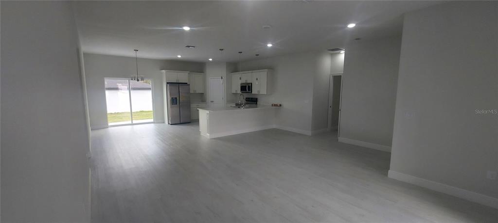 2673 Southwest 156th Place Ocala, FL 34473 - Photo 7 of 14 a view of a big room with wooden floor and a kitchen