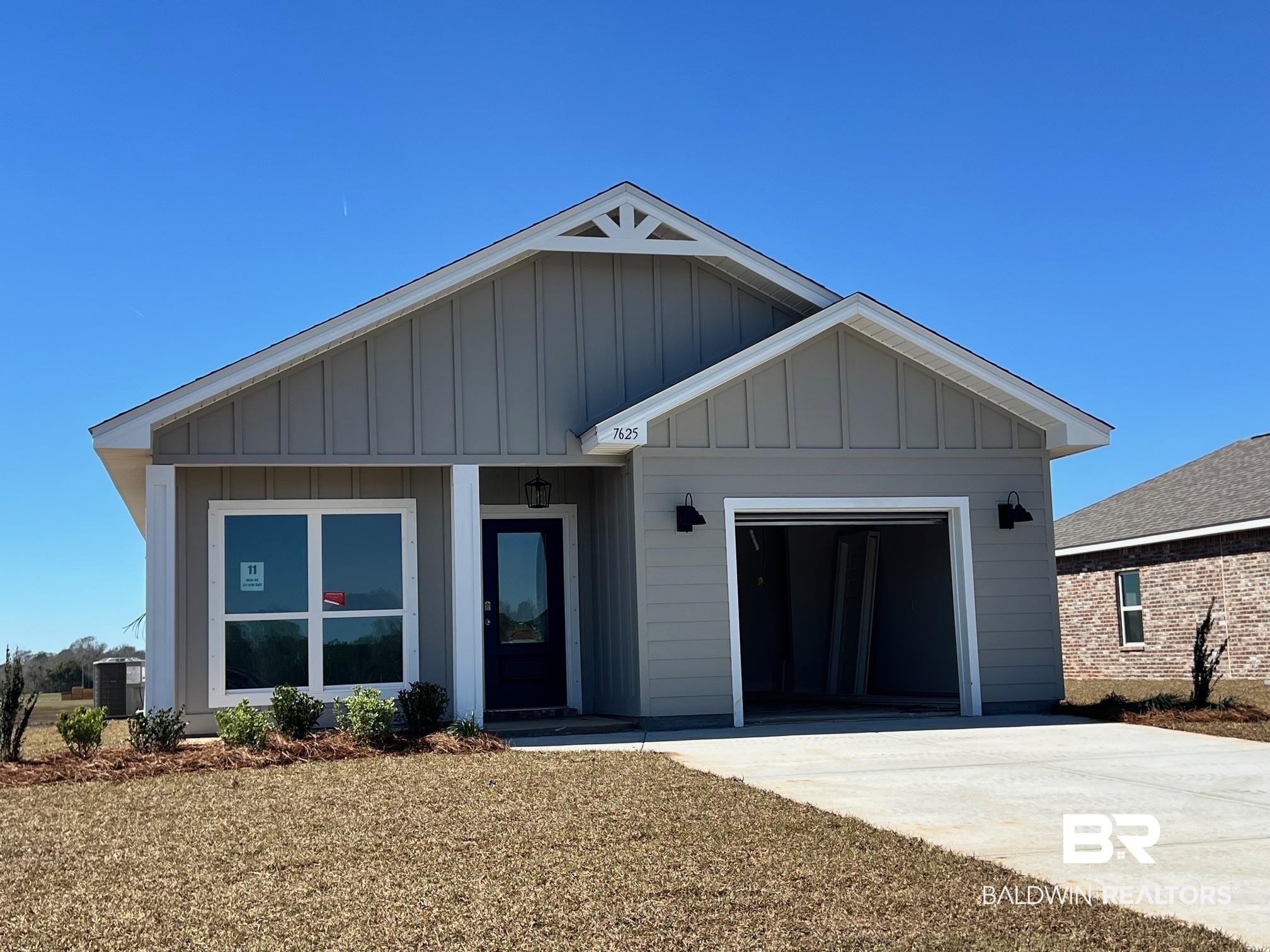 7625 Courant Circle Foley, AL 36535 - Photo 1 of 35 View of front facade with board and batten siding, an attached garage, and concrete driveway