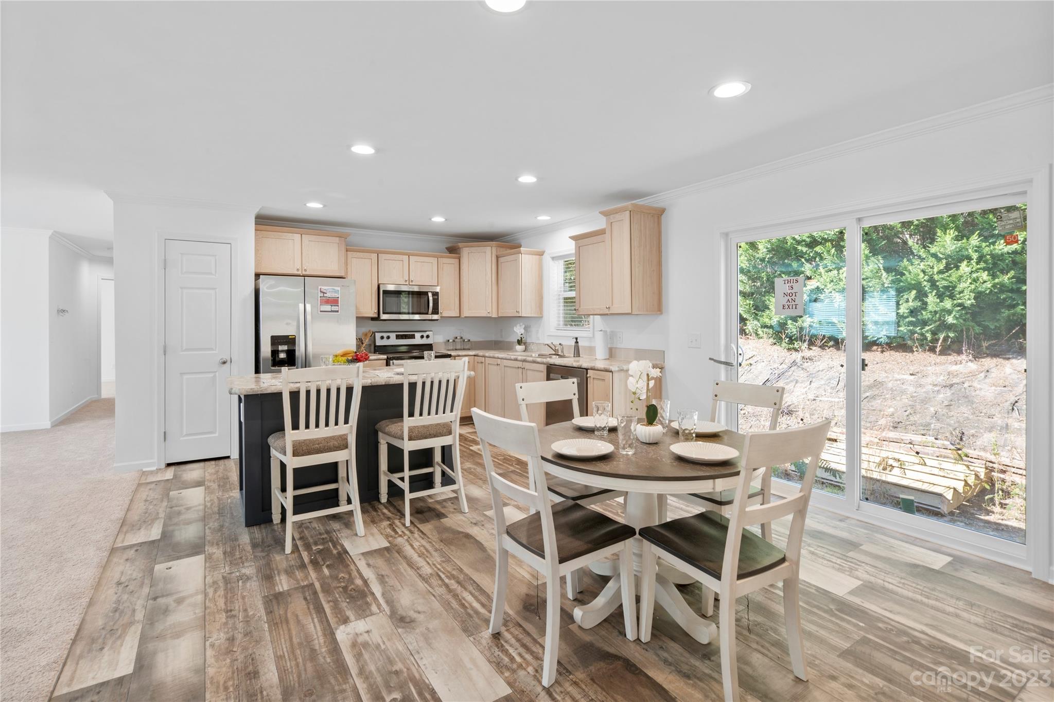 a kitchen with a dining table chairs and white appliances