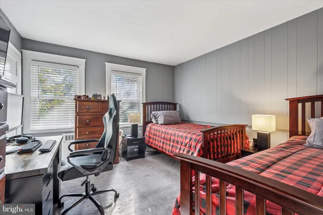a bedroom with two beds and a desk