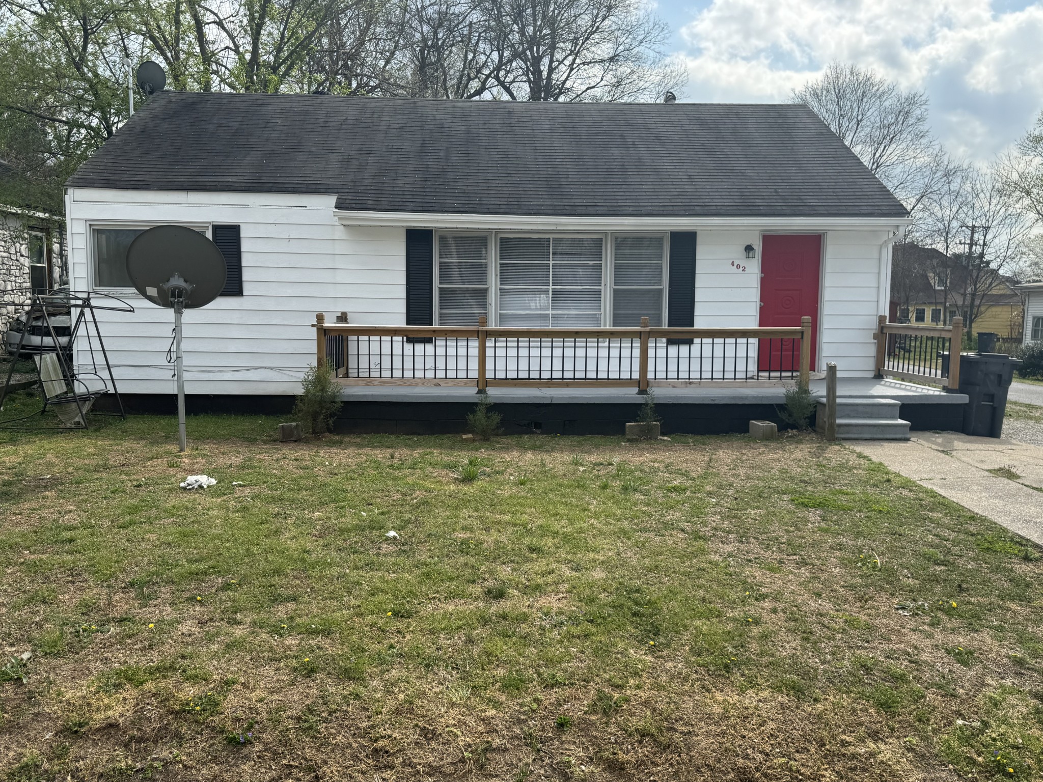 a view of a house with a wooden deck and a yard