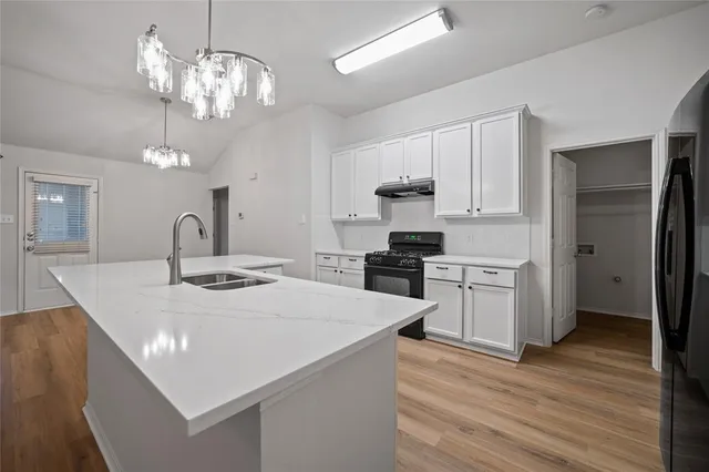 a kitchen with stainless steel appliances a kitchen island hardwood floor sink and stove