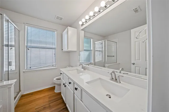a spacious bathroom with double vanity a mirror and a bathtub