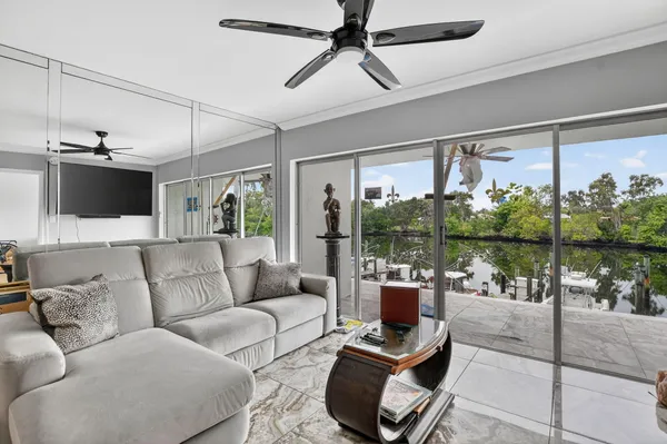 a living room with furniture and a large window with balcony view