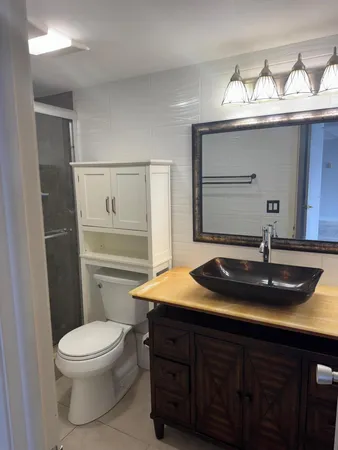 a bathroom with a shower a toilet and a sink