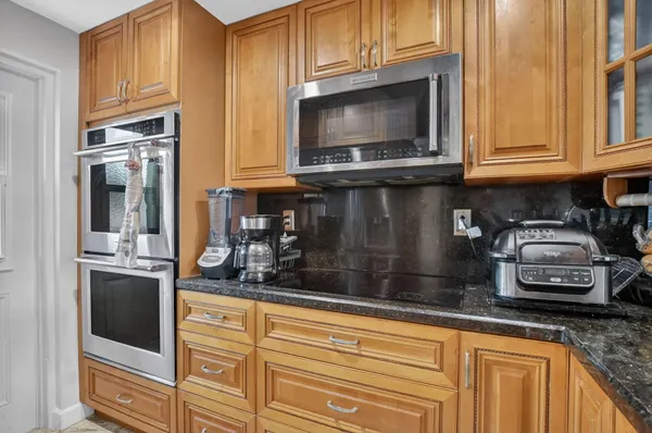 a kitchen with stainless steel appliances granite countertop a sink and a refrigerator