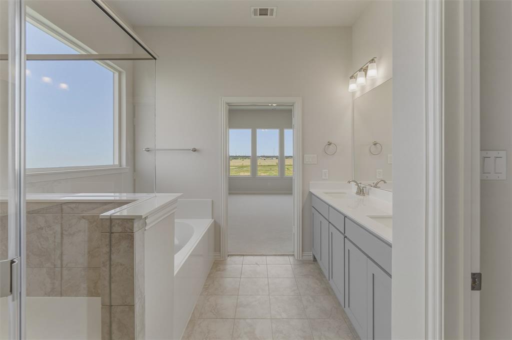 114 Hillview Trail Decatur, TX 76234 - Photo 18 of 27 Contemporary bathroom featuring a spacious walk-in shower with clear glass enclosure, a white soaking tub, and a dual vanity with light gray cabinetry and white countertops