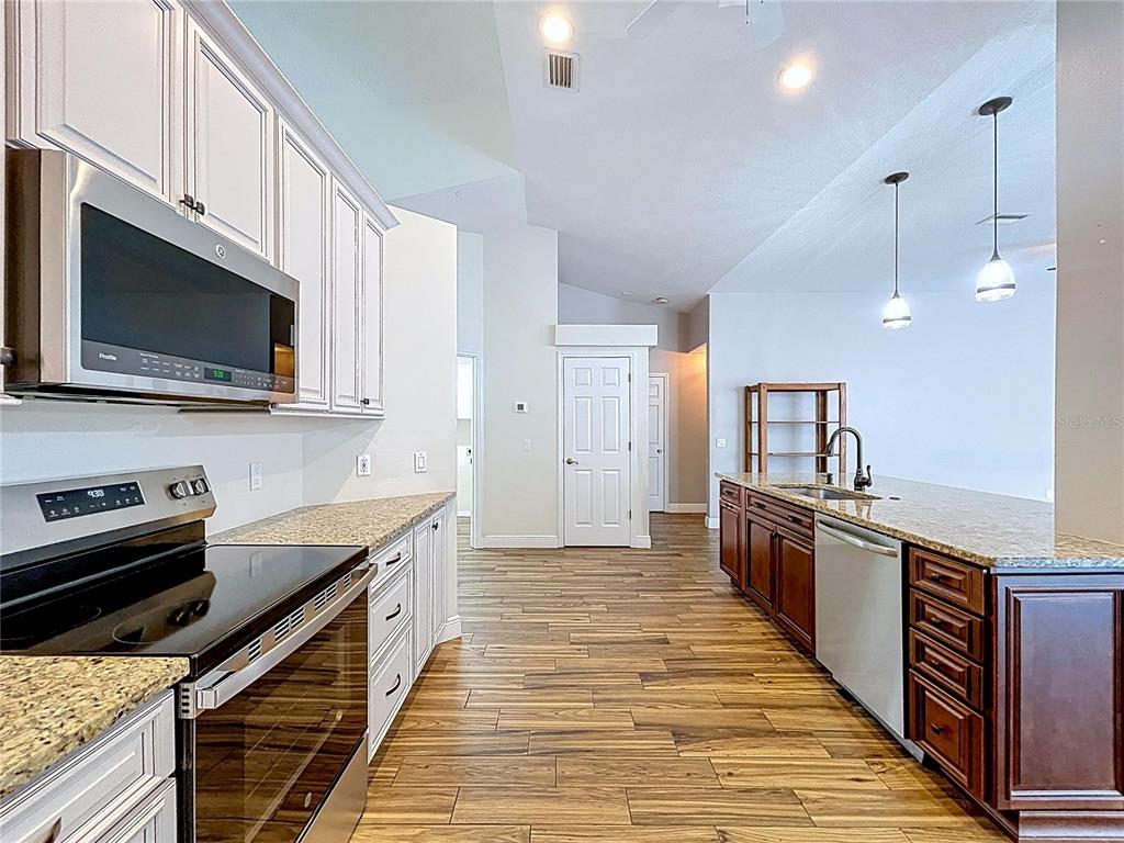 18812 Bascomb Lane Hudson, FL 34667 - Photo 34 of 57 a kitchen with stainless steel appliances granite countertop a sink a stove and a microwave