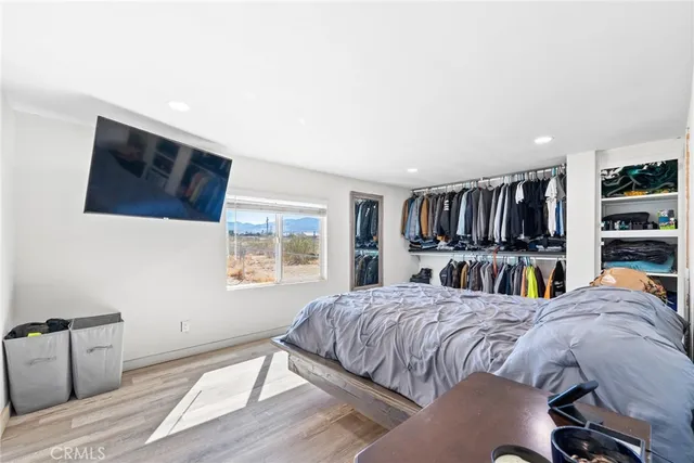 a bedroom with a bed a bookshelf and a window