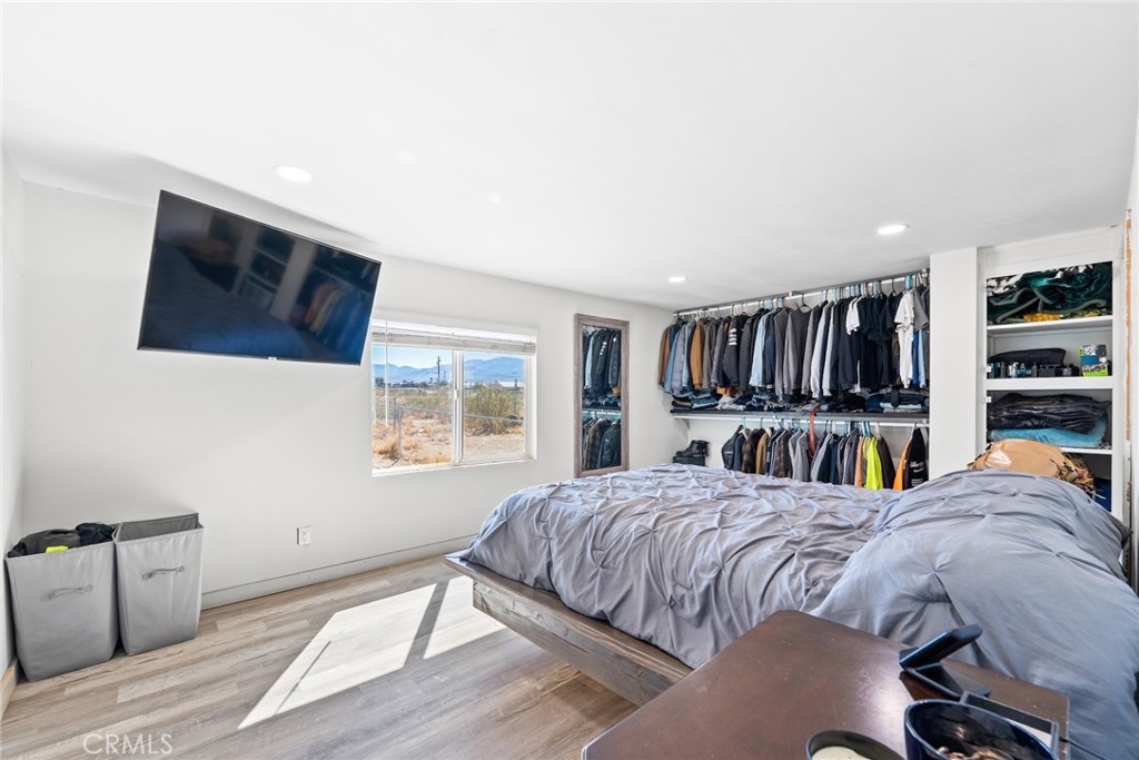 11772-11772 Middleton Road Phelan, CA 92371 - Photo 17 of 40 a bedroom with a bed a bookshelf and a window