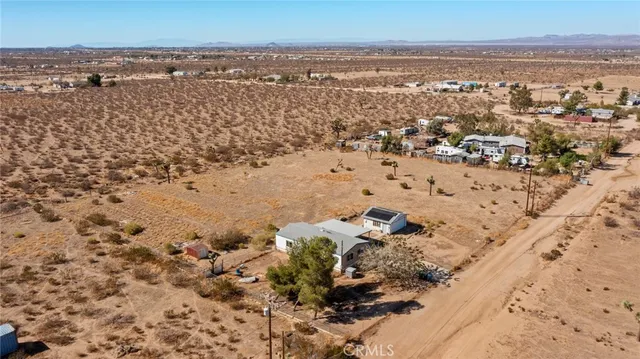 an aerial view of house with yard and mountain view in back