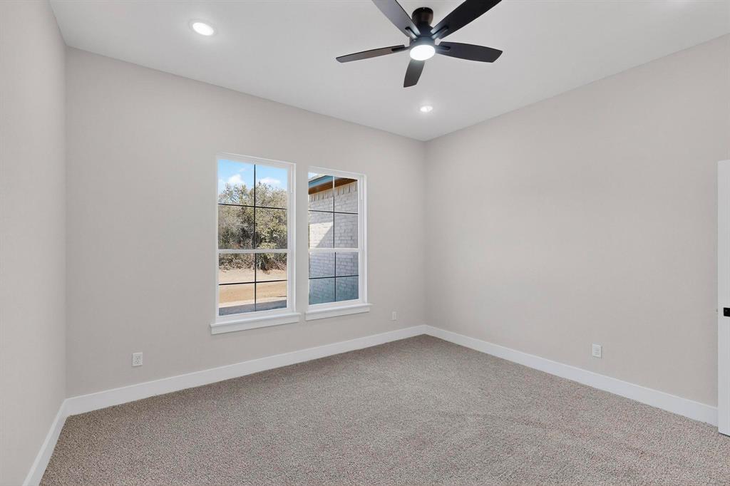 1161 Gonzollas Road Springtown, TX 76082 - Photo 21 of 40 an empty room with a window and a fan