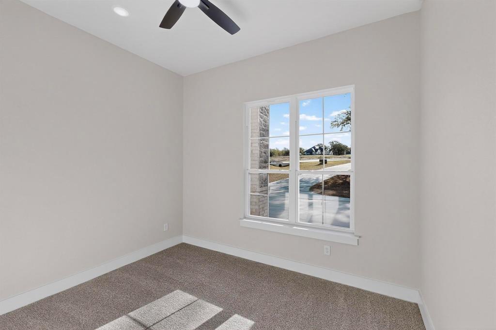 1161 Gonzollas Road Springtown, TX 76082 - Photo 32 of 40 an empty room with chandelier fan and windows