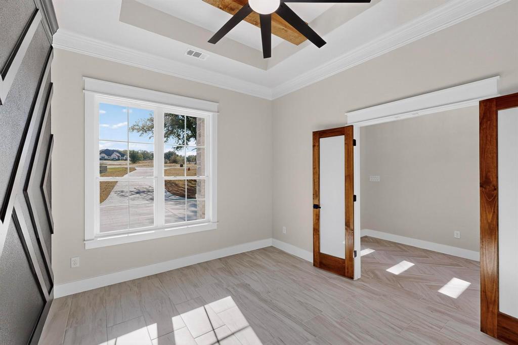 1161 Gonzollas Road Springtown, TX 76082 - Photo 5 of 40 a view of an empty room with wooden floor and a window