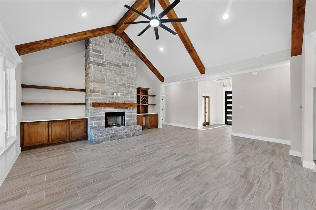 1161 Gonzollas Road Springtown, TX 76082 - Photo 8 of 40 an empty room with wooden floor fireplace and windows