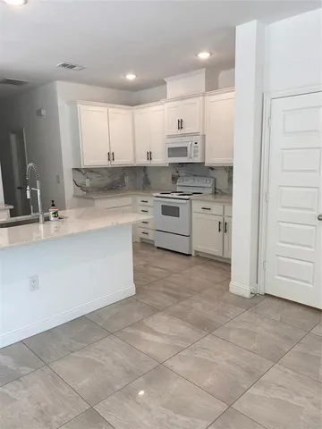 a kitchen with kitchen island cabinets and oven