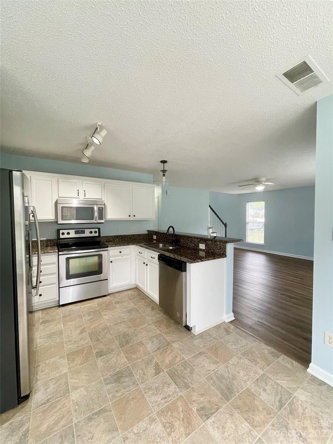 4045 Suttle Place Matthews, NC 28104 - Photo 14 of 42 a kitchen with granite countertop a stove and cabinets