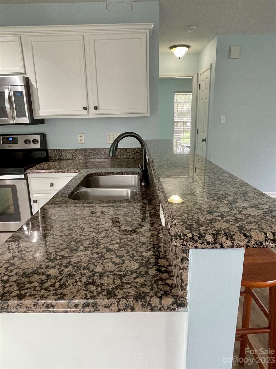 4045 Suttle Place Matthews, NC 28104 - Photo 16 of 42 a kitchen with kitchen island granite countertop a sink stove and cabinets