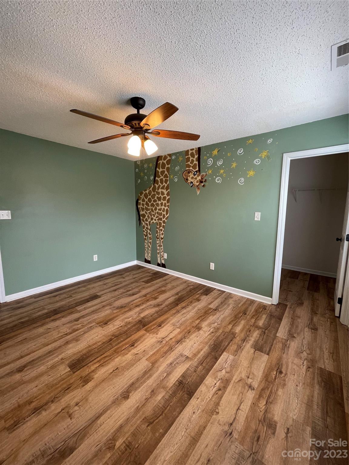 4045 Suttle Place Matthews, NC 28104 - Photo 28 of 42 an empty room with wooden floor chandelier fan and windows