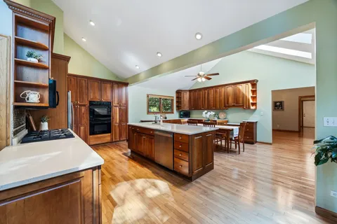 a kitchen with stainless steel appliances kitchen island granite countertop a stove and a refrigerator