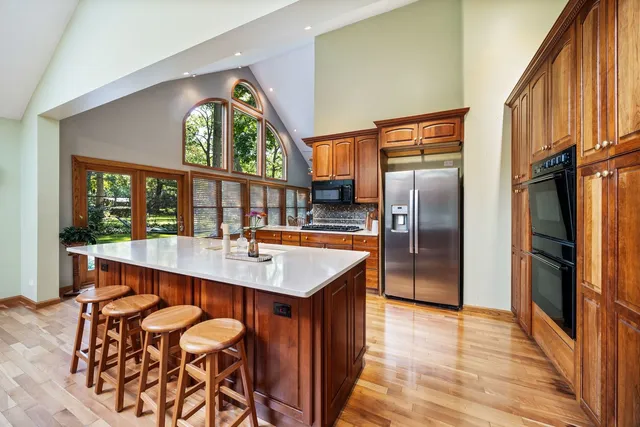 a kitchen with stainless steel appliances granite countertop a sink a kitchen island a stove and a refrigerator