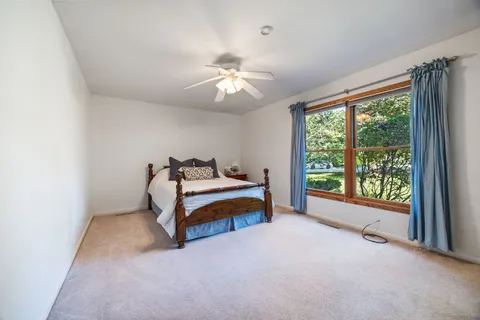 a bedroom with furniture and a large window
