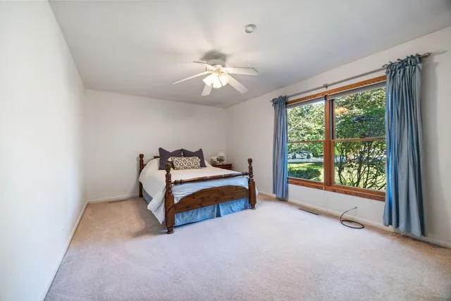 a bedroom with furniture and a large window