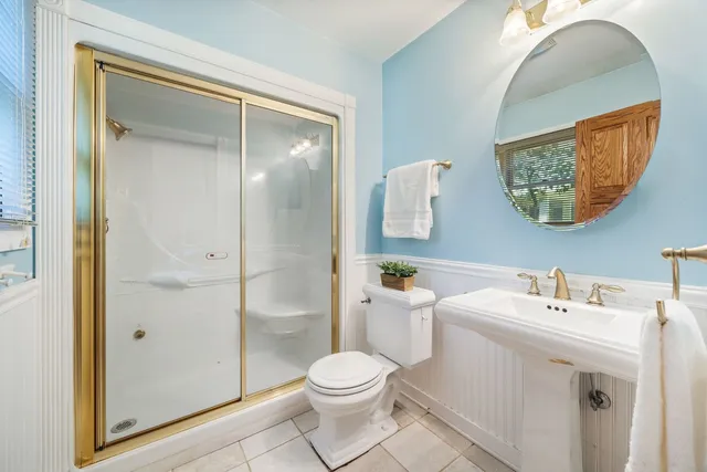 a bathroom with a toilet a sink a vanity and mirror