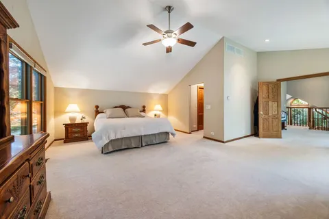 a spacious bedroom with a bed and a chandelier