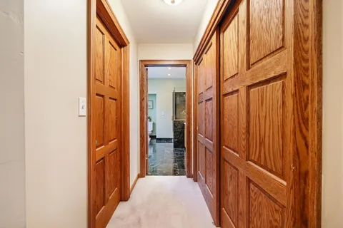 a view of a hallway with wooden floor and entryway