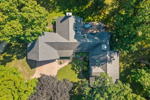 an aerial view of a house with a yard and a large tree