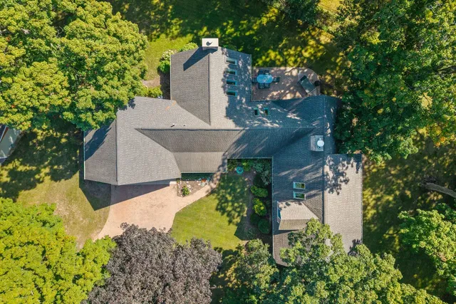 an aerial view of a house with a yard and a large tree