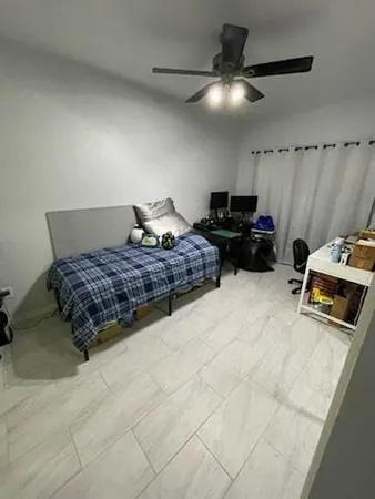 a bedroom with a bed and a ceiling fan