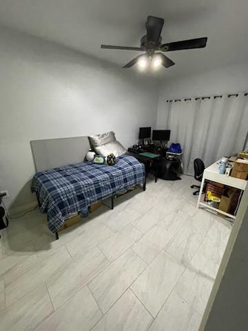806 West 24th Street, Unit 116 Austin, TX 78705 - Photo 5 of 9 a bedroom with a bed and a ceiling fan