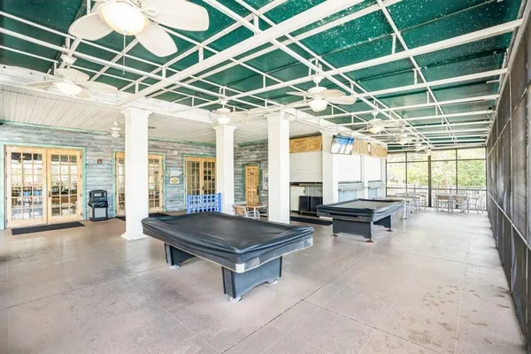a outdoor patio with swimming pool table and chairs