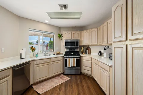 a kitchen with white cabinets sink and stainless steel appliances