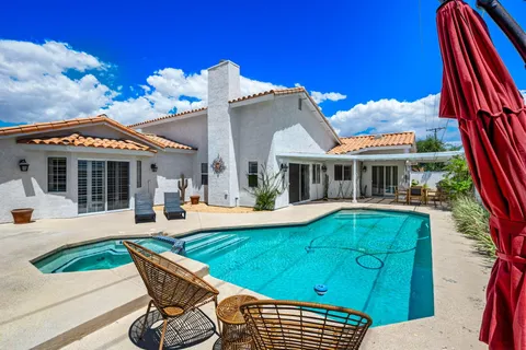 a view of a house with swimming pool and sitting area