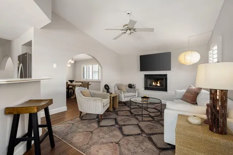 a living room with furniture a fireplace and a flat screen tv