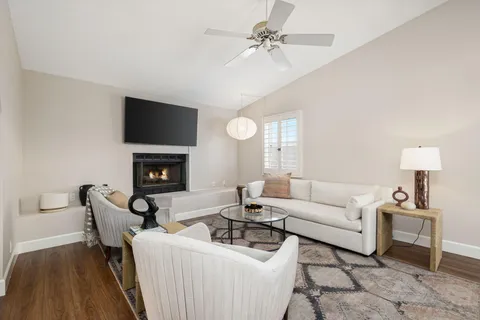 a living room with furniture a fireplace and a flat screen tv